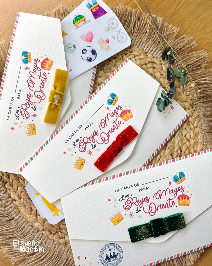 Varios broches de colores sobre tarjetas decorativas en una mesa de mimbre.
