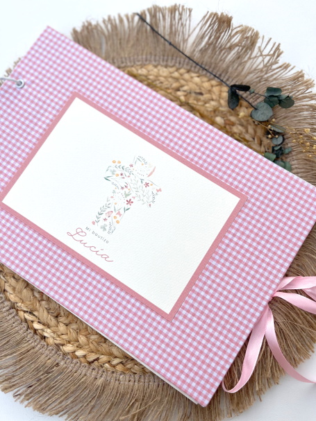 Cuaderno de cuadros rosa con un lazo, sobre un fondo de fibra natural.